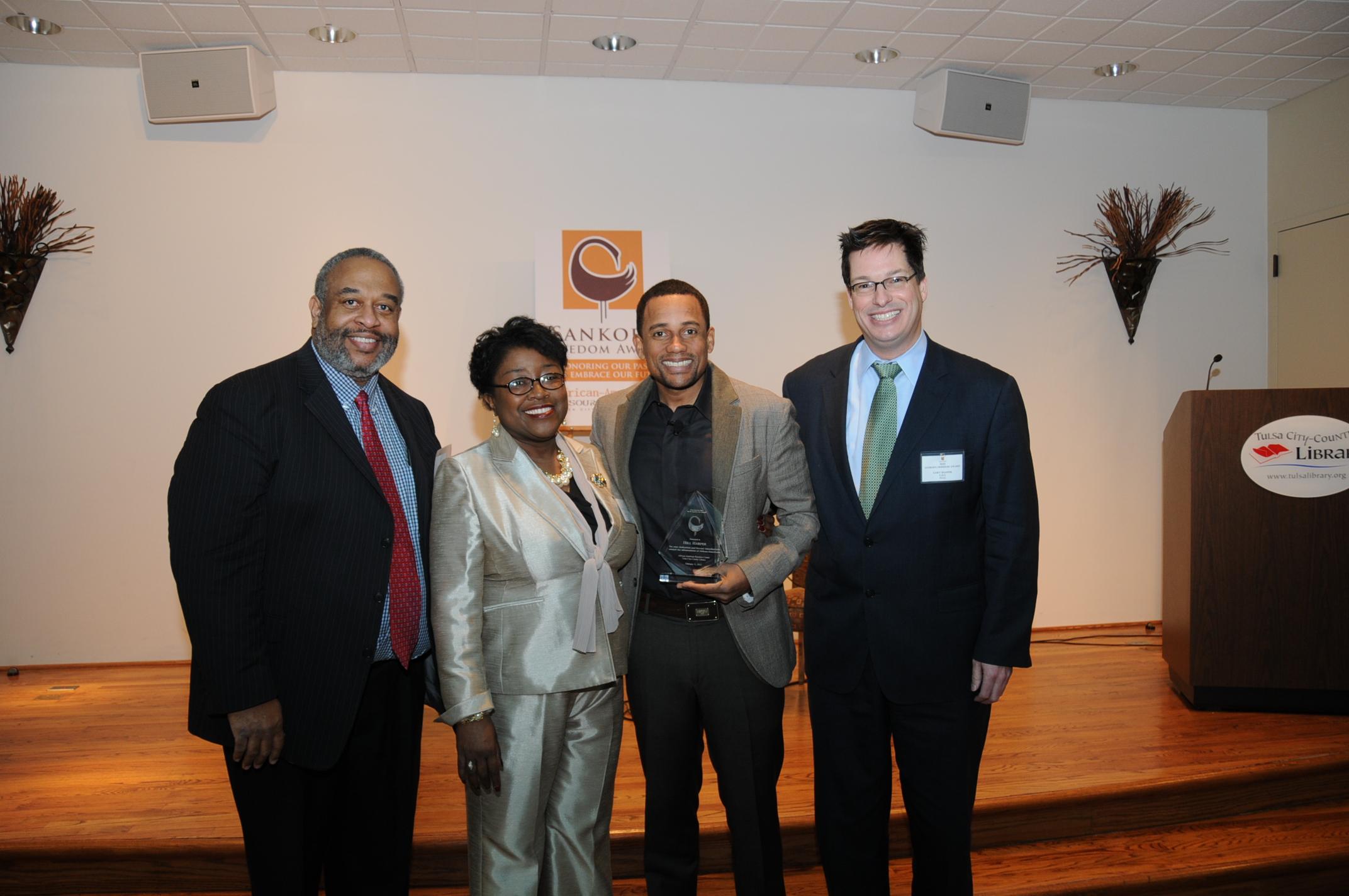 4 people standing together, one holding the Sankofa Award