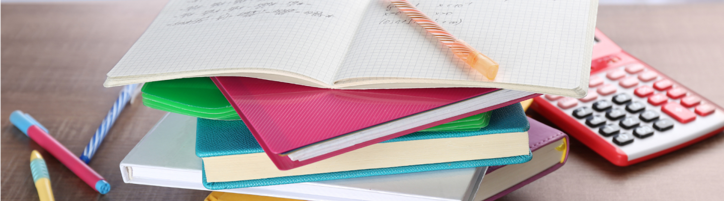 stack of notebooks and homework with pencil and a calculator