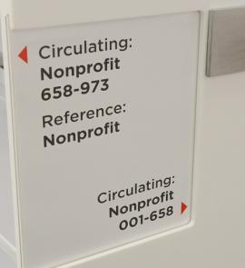 Nonprofit Resource Center shelves with directional signs pointing to reference and circulating nonprofit items.