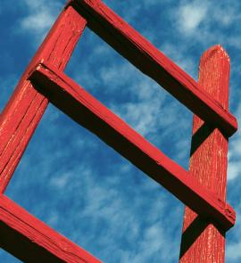 Top of a ladder with a sky background.